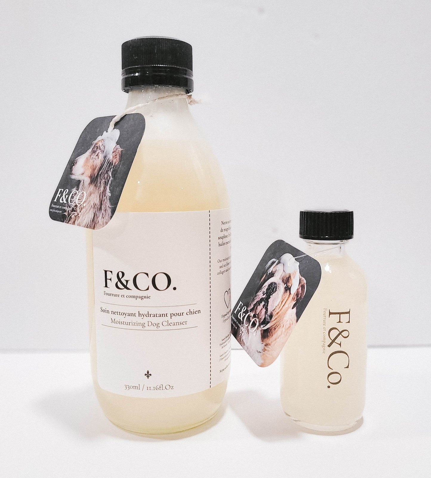 Les deux formats de shampoing pour chien. Grand et petit. Étiquette de carton, bouchon noir en plastique et étiquette blanche écris en noir.